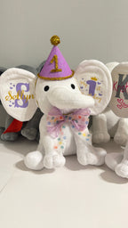 Custom stamped 'My First Birthday' plush elephant keepsake arranged as an upscale toddler milestone gift.