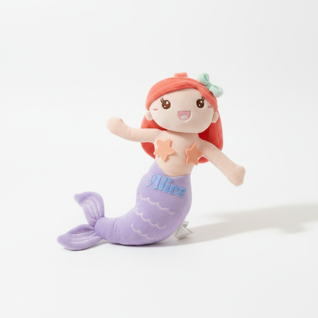 Custom stuffed mermaid plush toy with a purple tail and red hair, personalized with a stamped name.