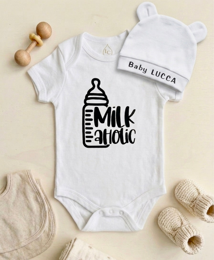 Custom stamped white baby bodysuit paired with a matching white bear-ear hat in a flat lay arrangement.