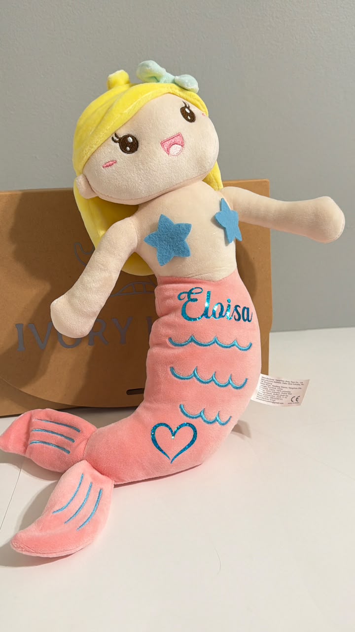 Personalized blonde mermaid plush doll with a pink tail, custom stamped for a unique baby gift.