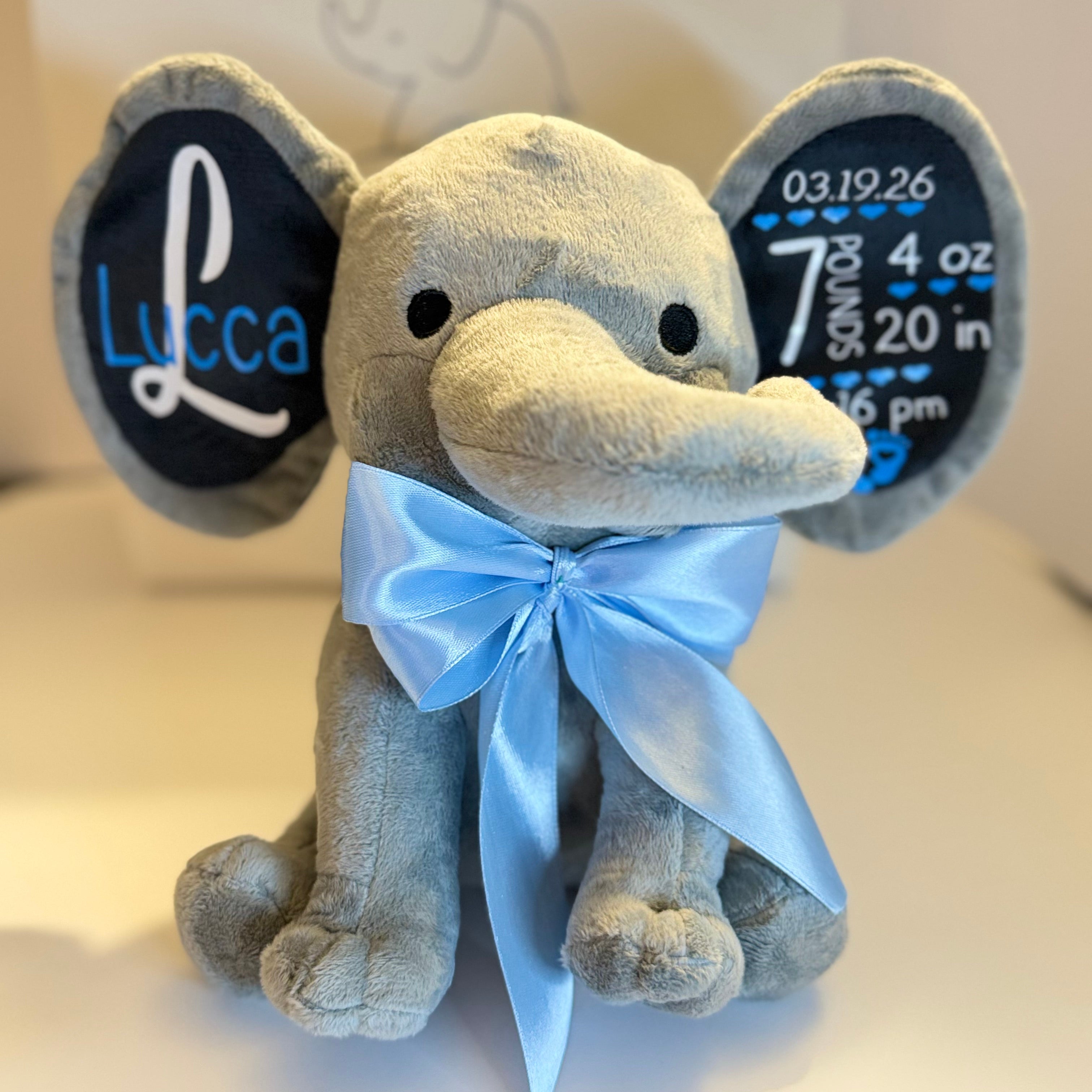 Ivory Heir personalized birth stats plush elephant in grey with customized name and baby birth details stamped on the ears.